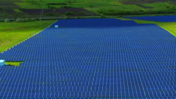 Megújuló energiatermelő gazdaság vidéki környezetben. Napelemek légi kilátósorai — Stock videók