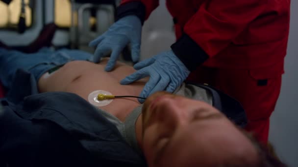 Ambulans paramediska händer utför hjärtmassage av skadad man — Stockvideo