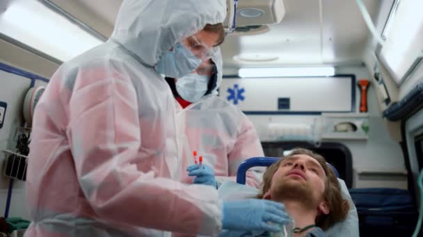 Médicos de emergência dando primeiros socorros ajuda ao paciente em carro de ambulância — Vídeo de Stock