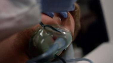 Paramedikler el kontrolü yapıyor. Doktor erkek hastayı muayene ediyor. 