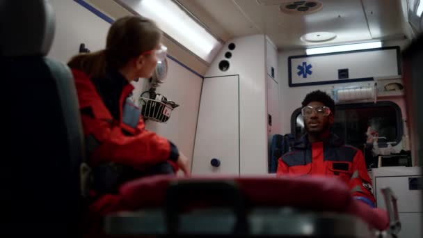 Serviço médico de emergência falando em carro de ambulância. Médicos vestindo uniforme — Vídeo de Stock