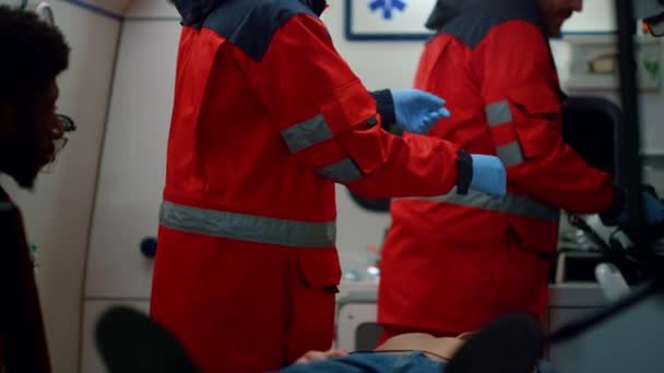 Los paramédicos preparan el desfibrilador para ayuda médica. Médicos reanimando al hombre — Vídeo de stock