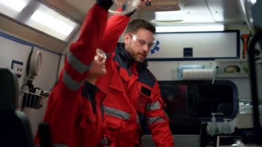 Ambulans ekibi trafik kazasına gidiyor. Sağlık görevlileri sedye hazırlıyor.