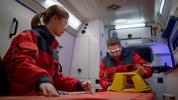 Týmoví zdravotníci se připravují na resuscitaci pacienta v nouzovém vozidle — Stock video