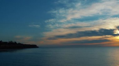 Gökyüzü ile panoramik kıyı şeridi görüntüsü. Meditasyon yapan deniz yüzeyi güneş ışığını yansıtıyor..