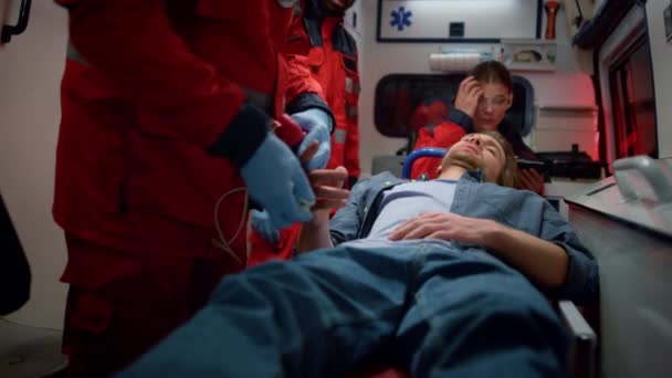 Paramédicos profesionales revisando el nivel de oxígeno en sangre de la víctima — Vídeos de Stock