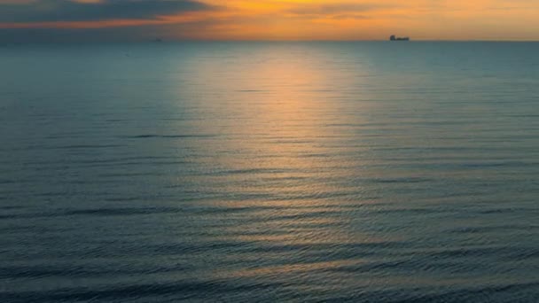 Tranquilla vista sulla superficie del mare. Acqua di mare blu che riflette raggi di tramonto dorati. — Video Stock