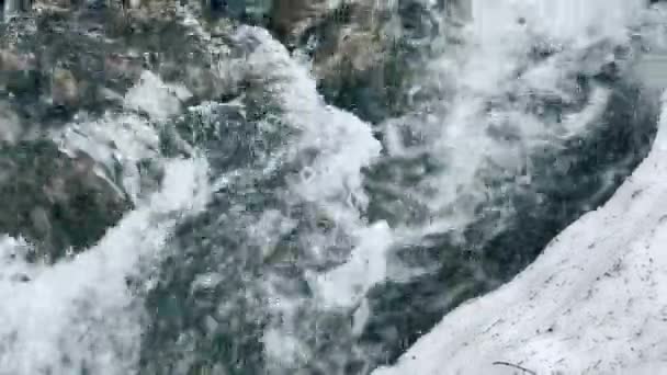 Bubbling river in winter snow. Closeup swift and frozen river with snowy banks. — Stock Video