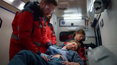 Acil servis asistanı ambulans arabasındaki hastaya tıbbi yardım sağlıyor.