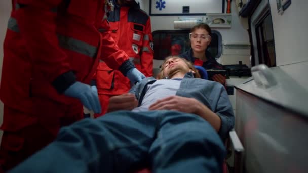 Assistenti di emergenza che esaminano il paziente in ambulanza — Video Stock