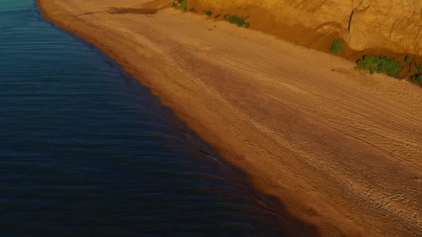 Drohnenblick auf das Meer mit friedlicher weißer Küste. Sonnig warmer Tag am Sandstrand. — Stockvideo