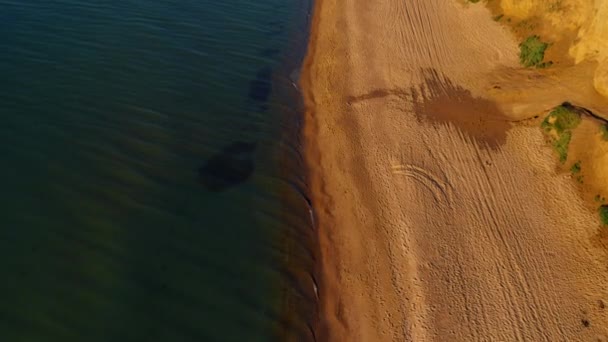 Vista aérea de la playa con agua tibia clara. Olas salpicando en la playa de arena. — Vídeo de stock