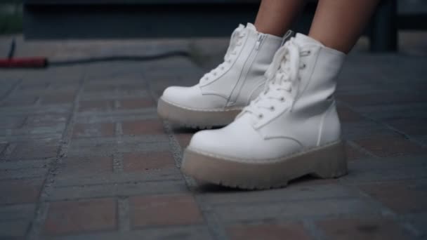 도시에서는 하얀 발 이 땅 위에서 움직이고 있습니다. 마을에 신발을 신고 있는 여자. — 비디오