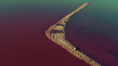 Pembe deniz yüzeyindeki hava manzaralı romantik ada. Renkli deniz suyu yüzeyi