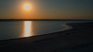 Altın gün batımı deniz suyu yüzeyine yansıyor. Havadaki kumsal sabah güneşinin doğuşu