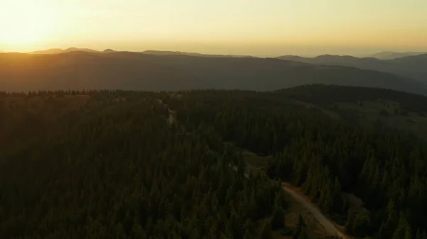 Aerial mountain sunrise view against golden morning sky green trees road scene — Φωτογραφία Αρχείου