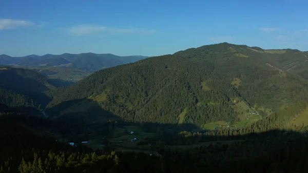 Aerial mountain valley village view with charming green rocky peaks blue sky — Stock Photo, Image