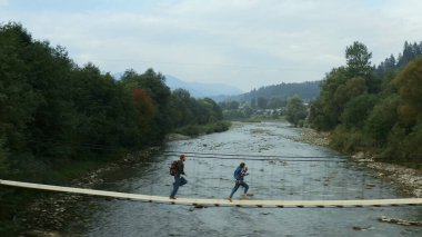 Aerial nature bridge couple running on having fun close small mountain river