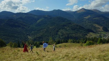Family against mountains dancing enjoying time looking green woods pikes