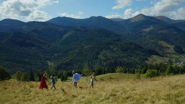 Familia contra montañas bailando disfrutando del tiempo buscando picas de bosques verdes — Foto de Stock