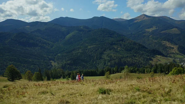 Children parents against hills walking together admiring beautiful landscape — стоковое фото