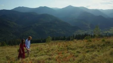 Joyful lovers in mountains drone view against amazing woods pikes background