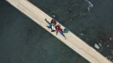 Mountain bridge couple lying with backpacks resting long trip enjoying time