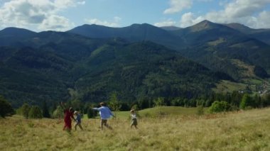 Family against mountains dancing enjoying time looking green woods pikes