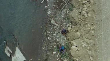 People walking mountain river hiking rocky bank enjoying adventure nature trip