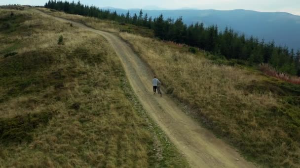 Homem com bicicleta vista montanha fazendo esporte ativo montanhoso estrada bosques fundo — Vídeo de Stock