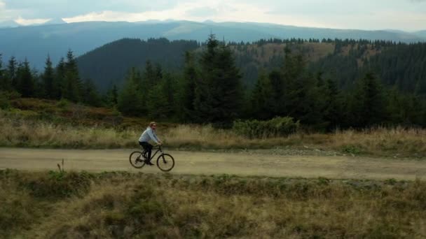 Mountain cycling drone view against stunning spruce forest hills enjoying time — Stockvideo