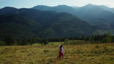 Lovers in mountains walking grass enjoying amazing landscape blue sky background