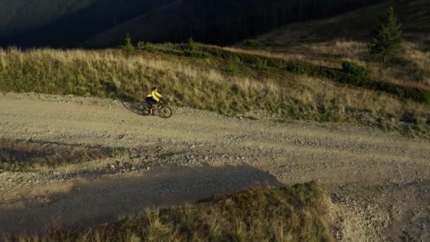 Aerial mountain road cycling view man biking among spring grass sunny day — Wideo stockowe