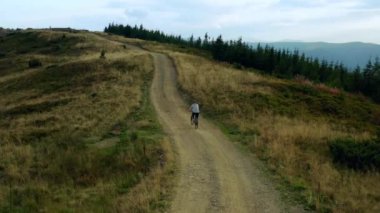 Aerial rocky road biking male view sport natural activity against cloudy sky