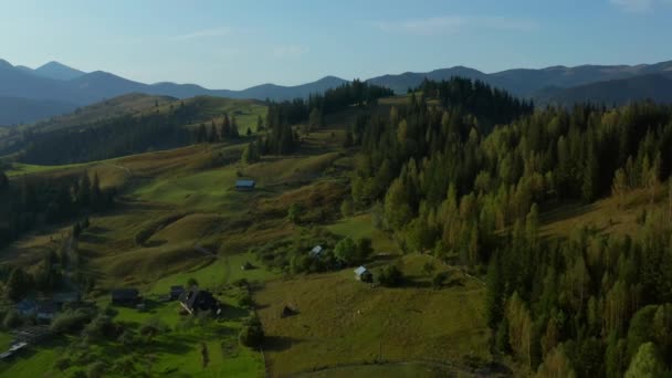 Drone lonely mountain buildings view green natural fields against blue sky — Stockvideo