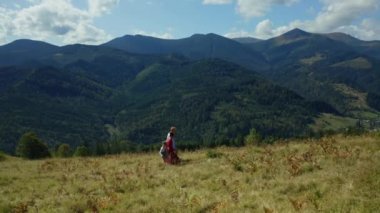 Family walking grass having fun together in summer mountains aerial view.