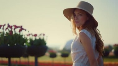 Sensual woman looking at camera outdoors. Beautiful girl turning face to sun. 