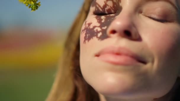 Bonita cara de menina cheirando ramo de árvore. Mulher bonita retrato sorrindo no parque. — Vídeo de Stock