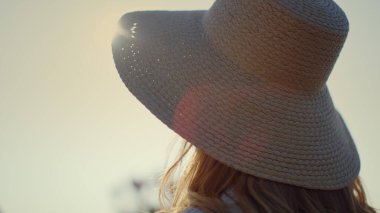 Beautiful woman turning face to camera. Portrait of young lady enjoying sunlight