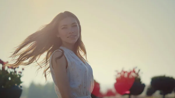 Relaxed woman with waving hair walking in summer park in sun reflection outside. — Fotografia de Stock