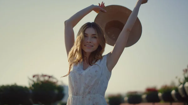 Attraktives Mädchen, das an einem sonnigen Tag seinen Sonnenhut auszieht. Junge Dame genießt den Frühling. — Stockfoto