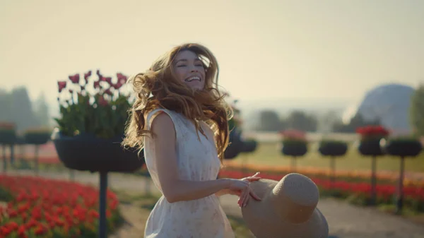 Happy girl with flowing hair jumping in summer garden. Beautiful woman laughing. — Foto Stock