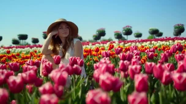 Mujer relajada sentada en un hermoso jardín de primavera. Vista del campo de tulipán en flor. — Vídeo de stock