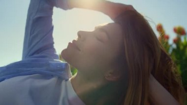 Pretty girl feeling happy in sunlight. Confident woman playing with blond hair.