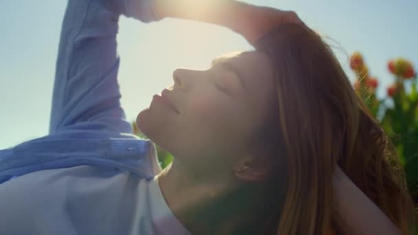 Mooi meisje die zich gelukkig voelt in het zonlicht. Zelfverzekerde vrouw spelen met blond haar. — Stockvideo