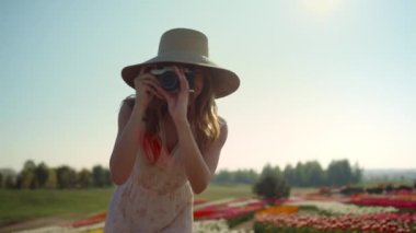 Professional woman photographer making photo in beautiful garden with flowers.