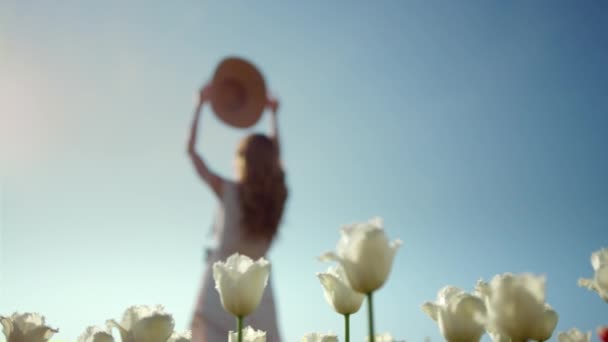 Woman silhouette wearing hat in flower garden. Unrecognizable girl on vacation. — Stock videók