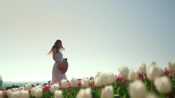 Счастливая девушка оборачивается в саду тюльпанов. — стоковое видео