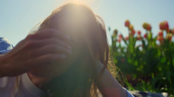 Ρομαντικό μπλε μάτια γυναίκα χαλαρώνοντας στο μαλακό φως του ήλιου στο φόντο πεδίο τουλίπας. — Αρχείο Βίντεο