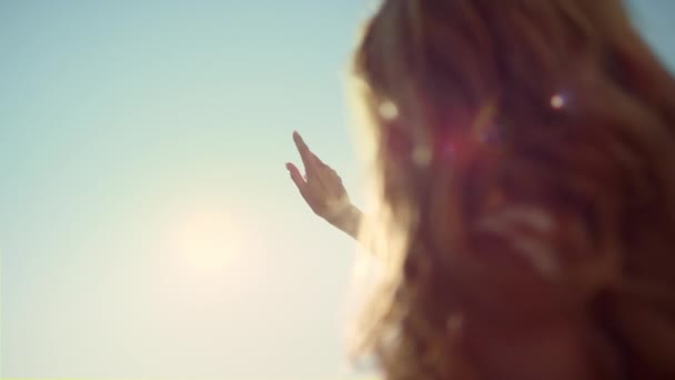 Close up sunbeam throught woman fingers. Woman back with hand touching sunshine. — Vídeos de Stock